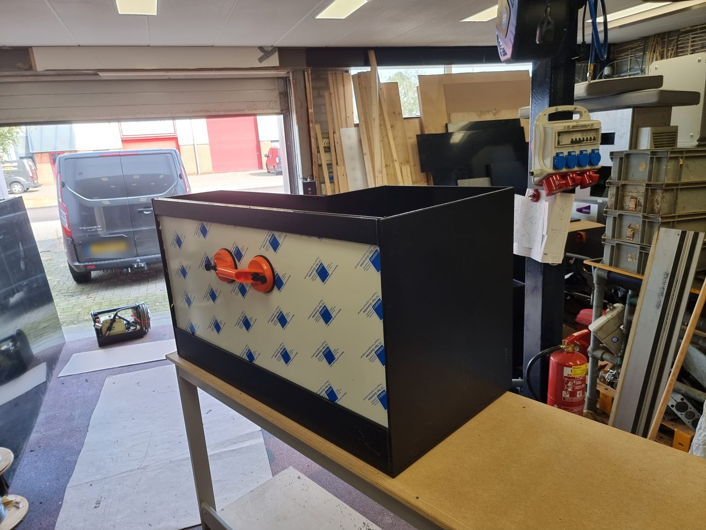 Kast met Lexan paneel in de werkplaats, met de uitsparing waar de paal in past