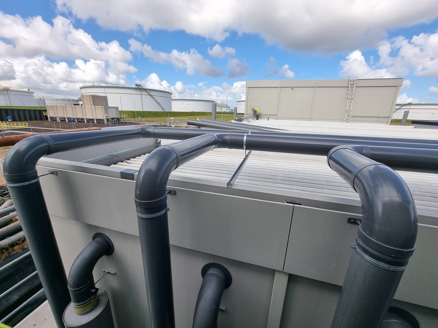 PVC-hoofdleidingen op het dak met bochten en aftakkingen naar de gevel