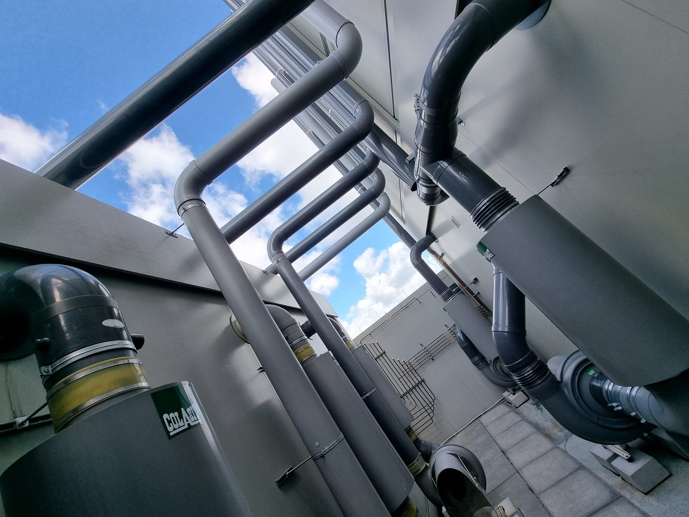 Leidingwerk van onderaf gezien: dempers, ventilatoren en bochten