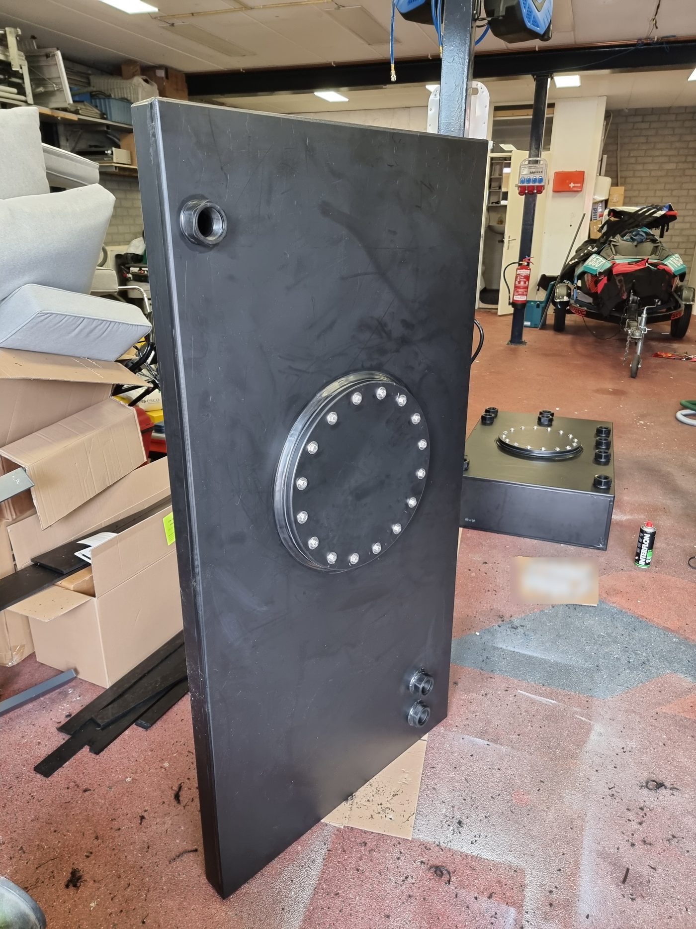 Hoge tank met mangat in de werkplaats