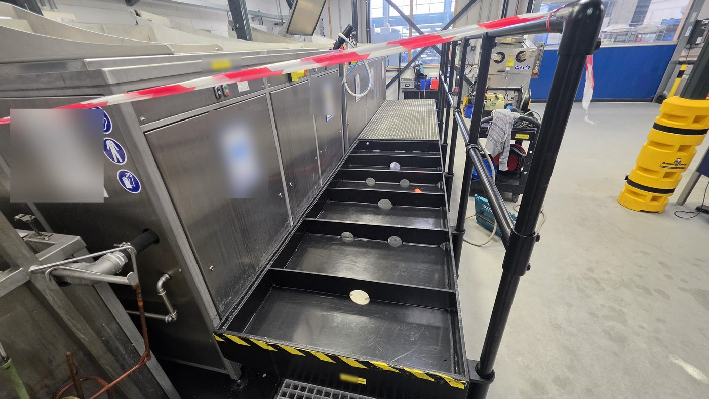 Opvangbakken in zwart PE langs een procesinstallatie